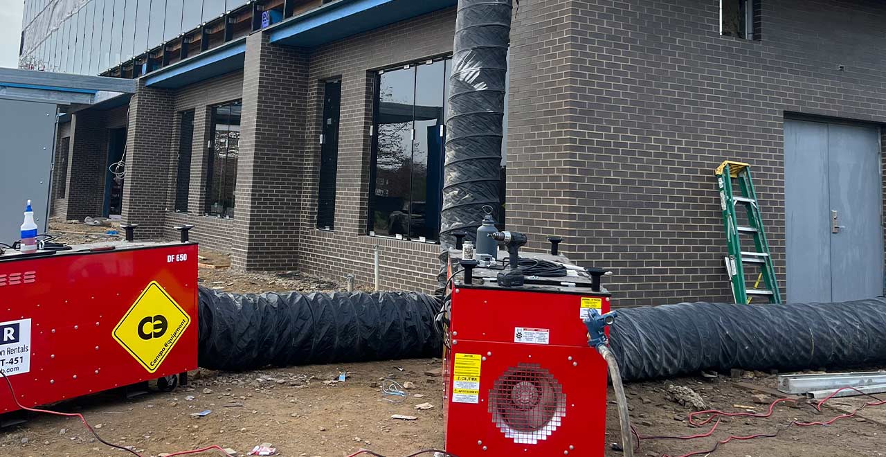 Industrial construction site with heavy equipment and ventilation ducts for REIC Specialty Rentals.