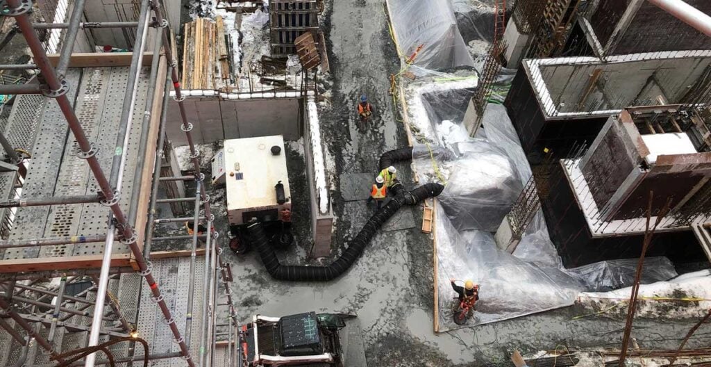 Heavy construction site with industrial ventilation system for building project.